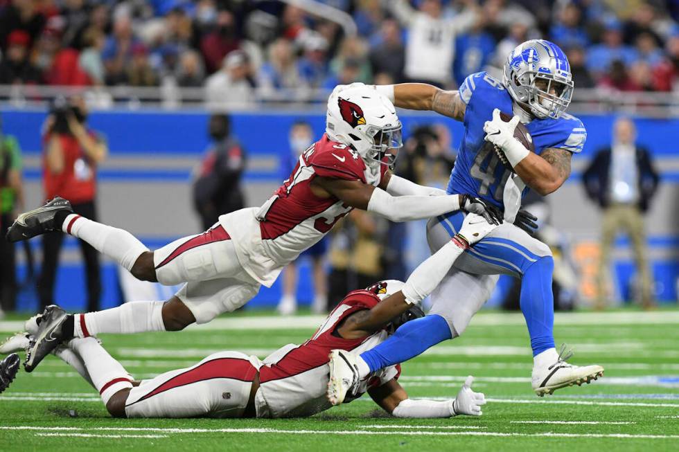 Detroit Lions running back Craig Reynolds is caught by Arizona Cardinals free safeties Jalen Th ...
