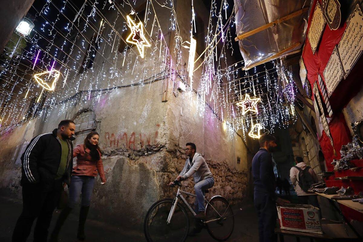 People walk in the Old City of Damascus, Syria, decorated for the upcoming Christmas holidays, ...