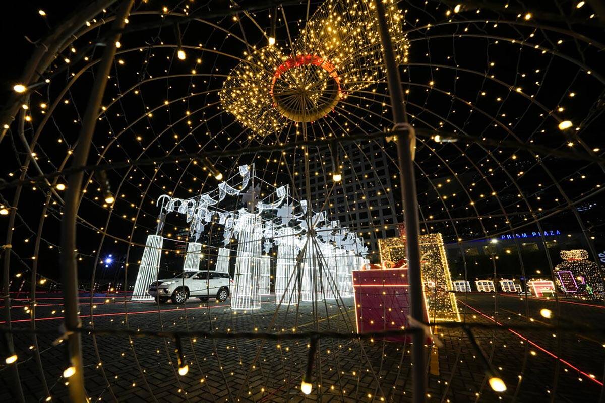 A car passes by Christmas displays at a drive-thru Christmas installation outside a mall in Pas ...
