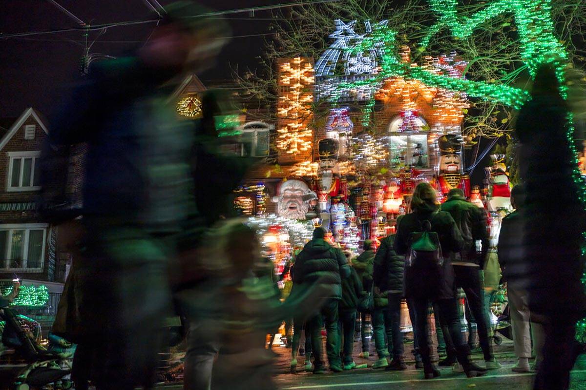 People crowd around holiday lights and decorations which adorn a house in Brooklyn's Dyker Heig ...