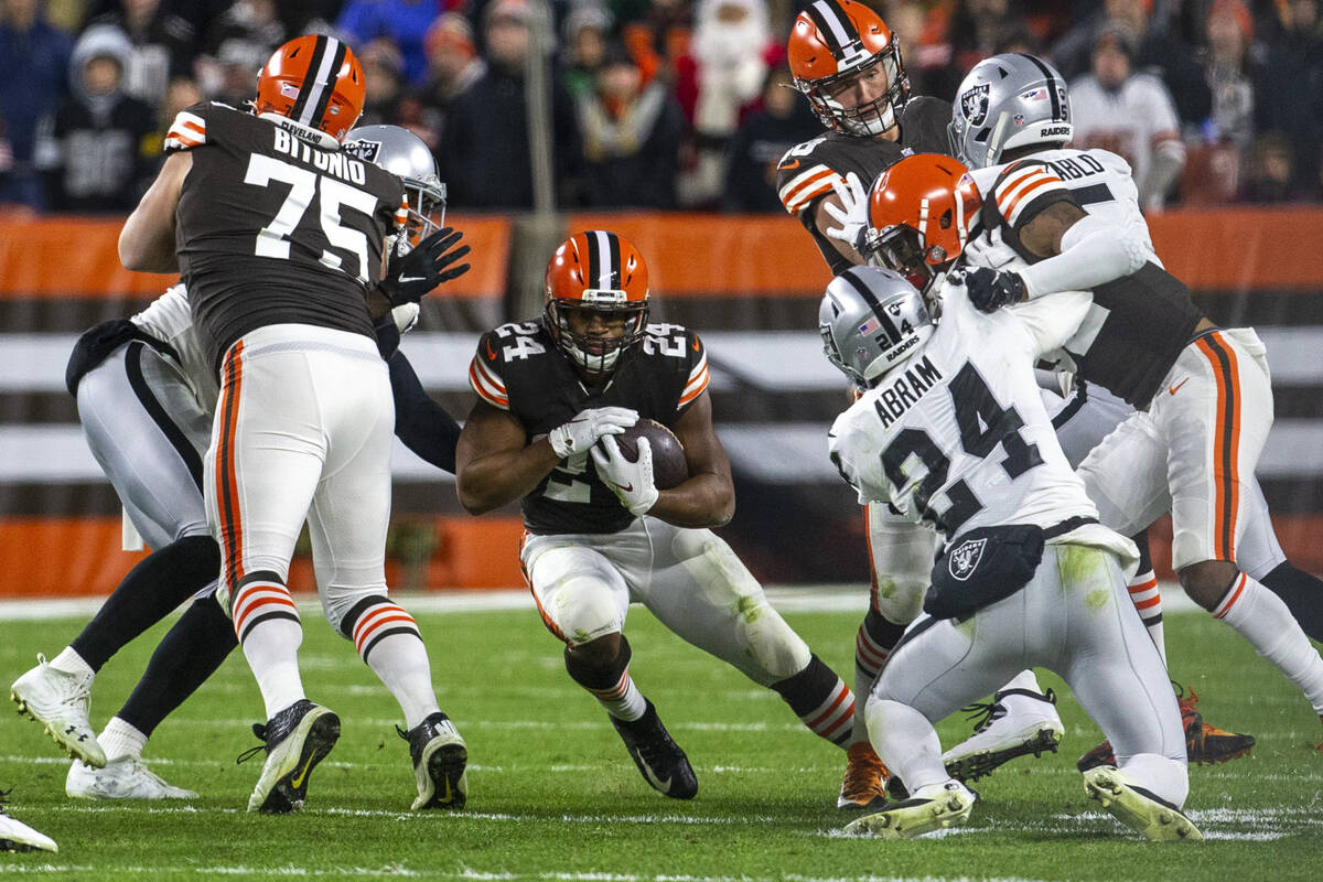 Cleveland Browns running back Nick Chubb (24) looks for room to run as Raiders safety Johnathan ...