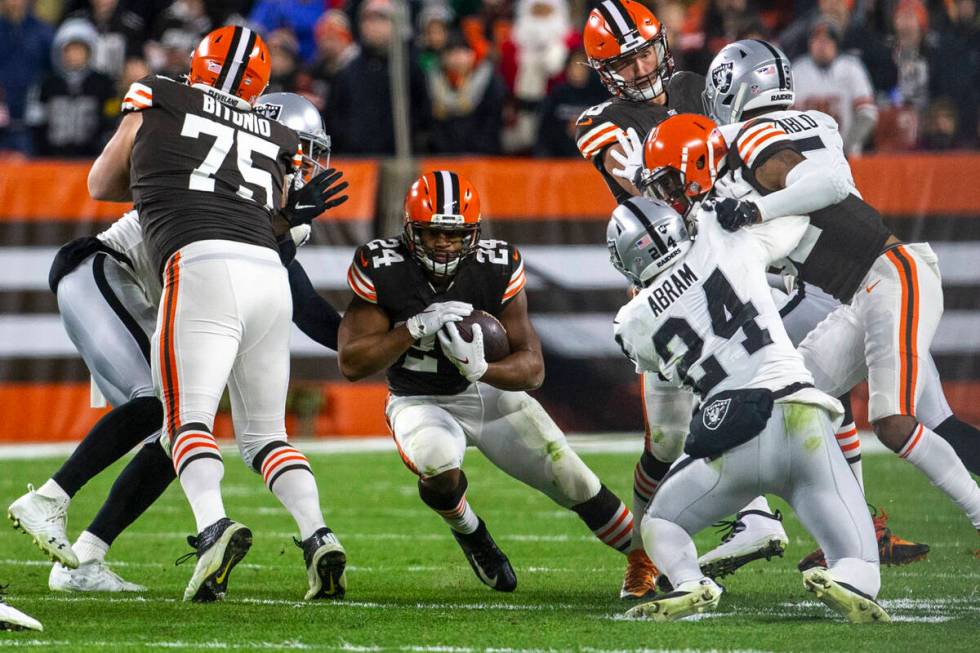 Cleveland Browns running back Nick Chubb (24) looks for room to run as Raiders safety Johnathan ...