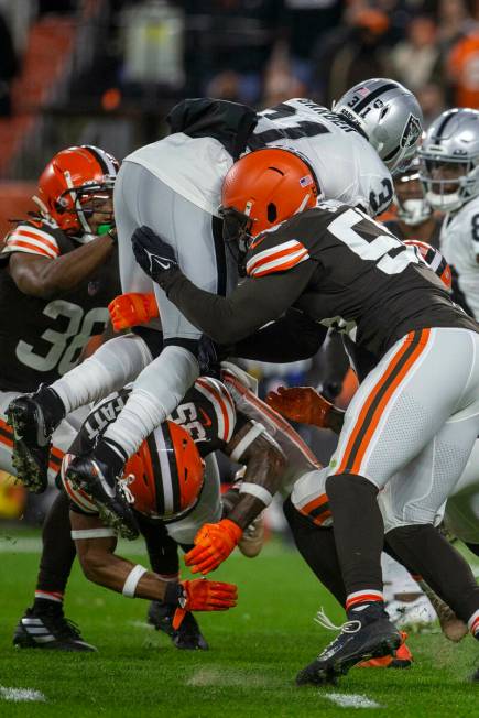 Raiders running back Peyton Barber (31) leaps over Cleveland Browns middle linebacker Malcolm S ...