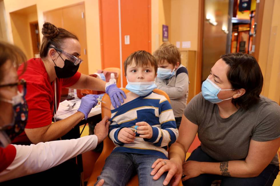 Cullen Fowler, 5, of Pahrump gets a COVID-19 vaccination from Yvette Rhebok as his mother, Eliz ...