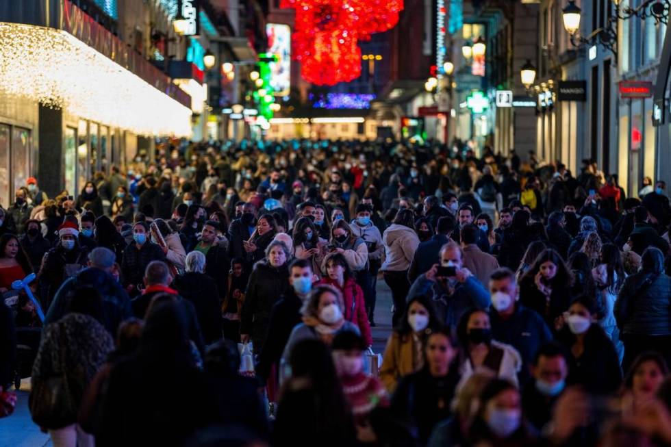 People wearing face masks to curb the spread of coronavirus walk in downtown Madrid, Spain, Tue ...