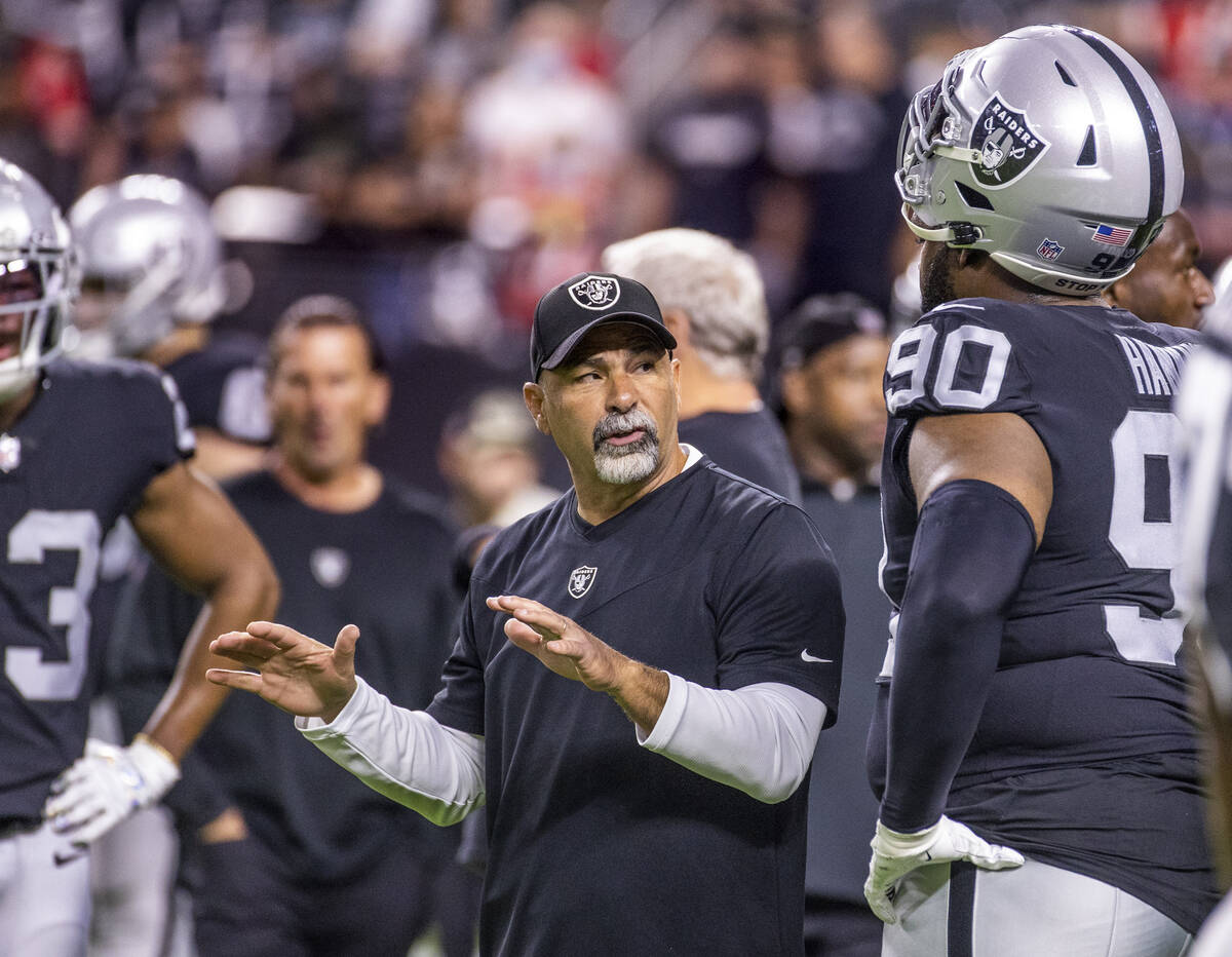 Raiders interim head coach Rich Bisaccia talks with Raiders defensive tackle Johnathan Hankins ...