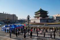 In this photo released by China's Xinhua News Agency, residents line up for tests at a COVID-19 ...