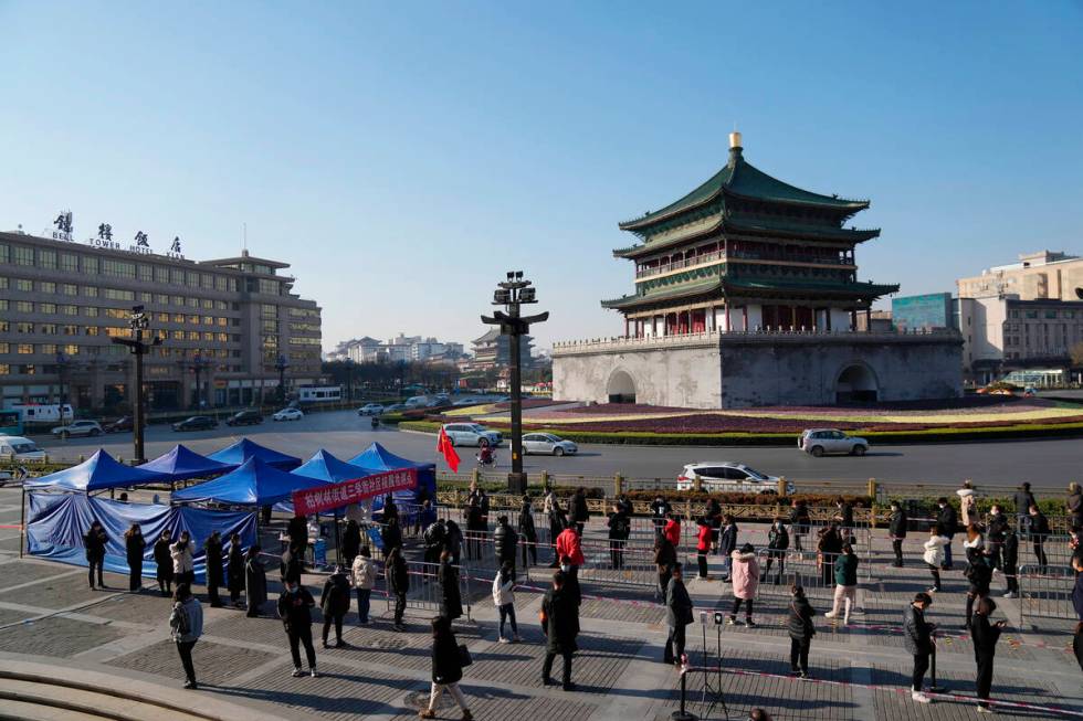 In this photo released by China's Xinhua News Agency, residents line up for tests at a COVID-19 ...