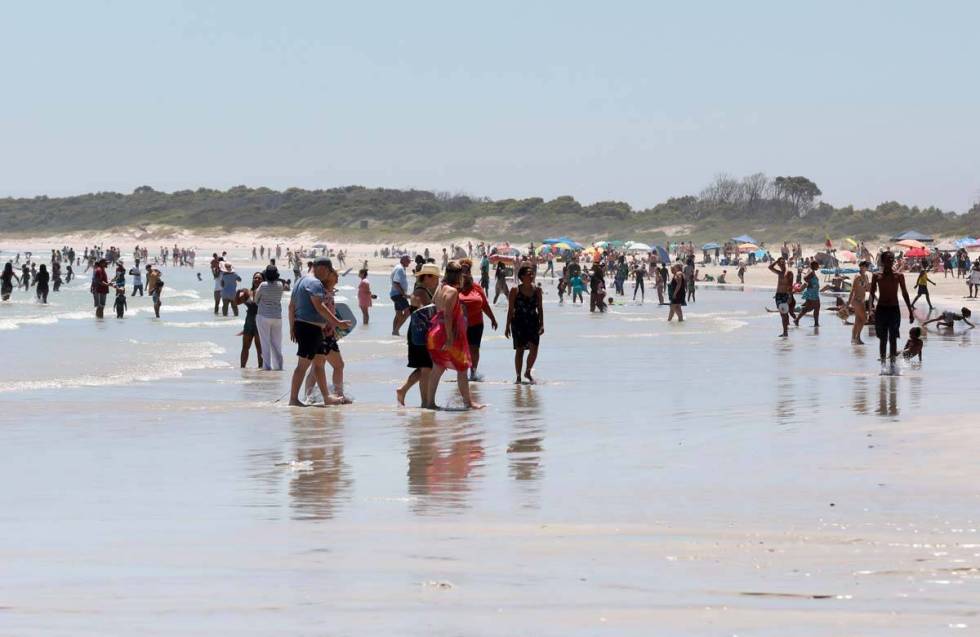 Holdiaymakers enjoy a day at Strand Beach near Cape Town, South Africa, Tuesday, Dec. 21, 2021. ...