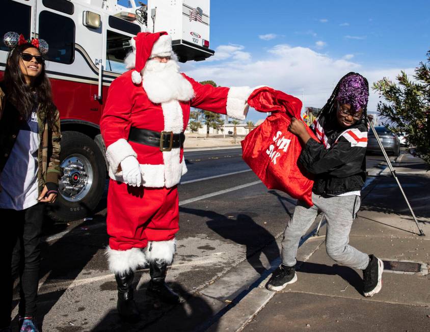 Aujanae Holland receives gifts from Santa at her residence on Friday, Dec. 24, 2021, in North L ...