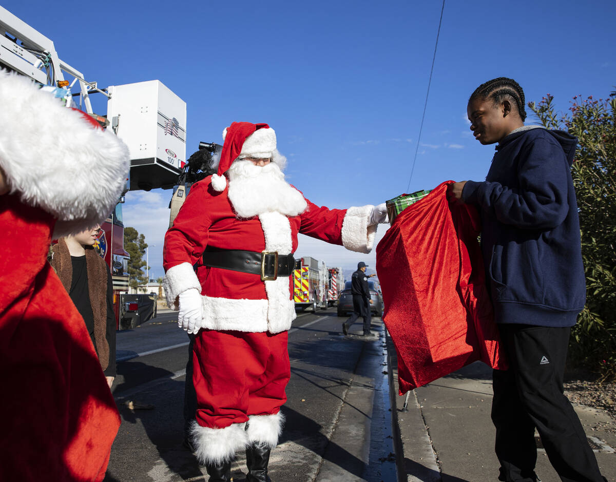 Damien Holland (15) receives gifts from Santa at his residence on Friday, Dec. 24, 2021, in Nor ...