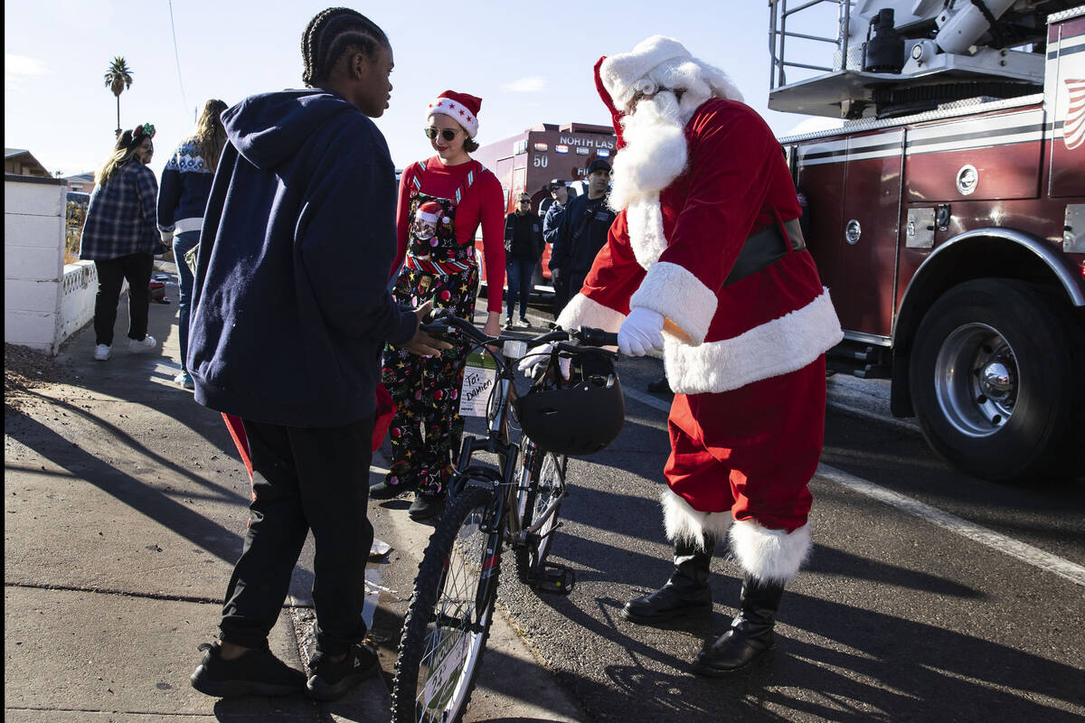 Damien Holland (15) receives a bicycle from Santa at his residence on Friday, Dec. 24, 2021, in ...