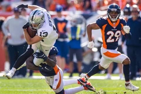 Raiders wide receiver Hunter Renfrow (13) is tackled by Denver Broncos safety Kareem Jackson (2 ...