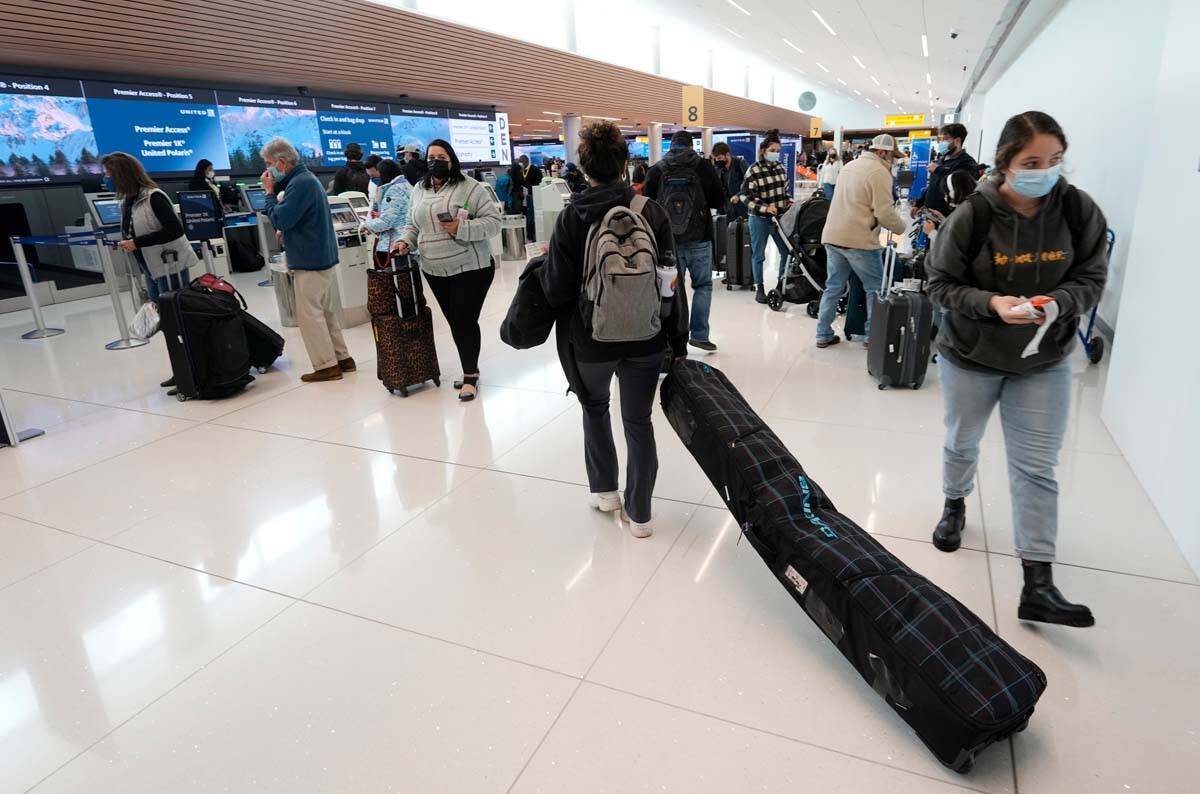A traveler pulls a ski bag on the way to the check-in counter for United Airlines in a terminal ...