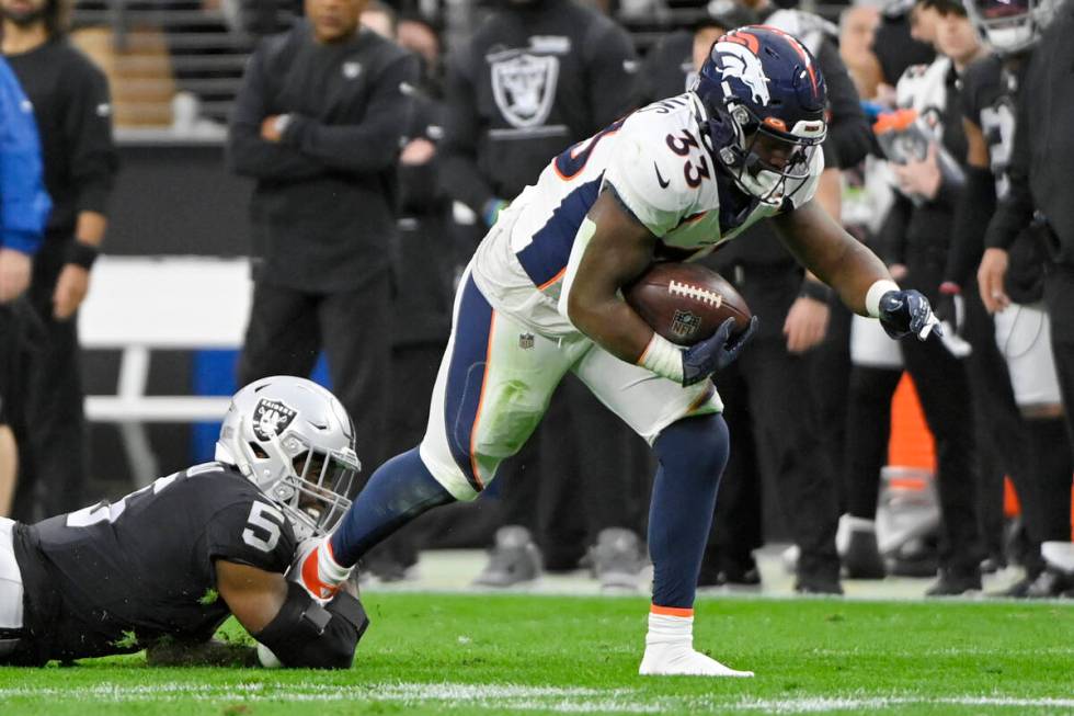 Las Vegas Raiders linebacker Divine Deablo (5) attempts to tackle Denver Broncos running back J ...