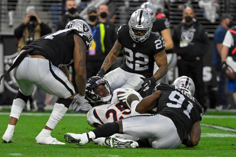 Las Vegas Raiders defensive end Yannick Ngakoue (91) tackles Denver Broncos running back Melvin ...