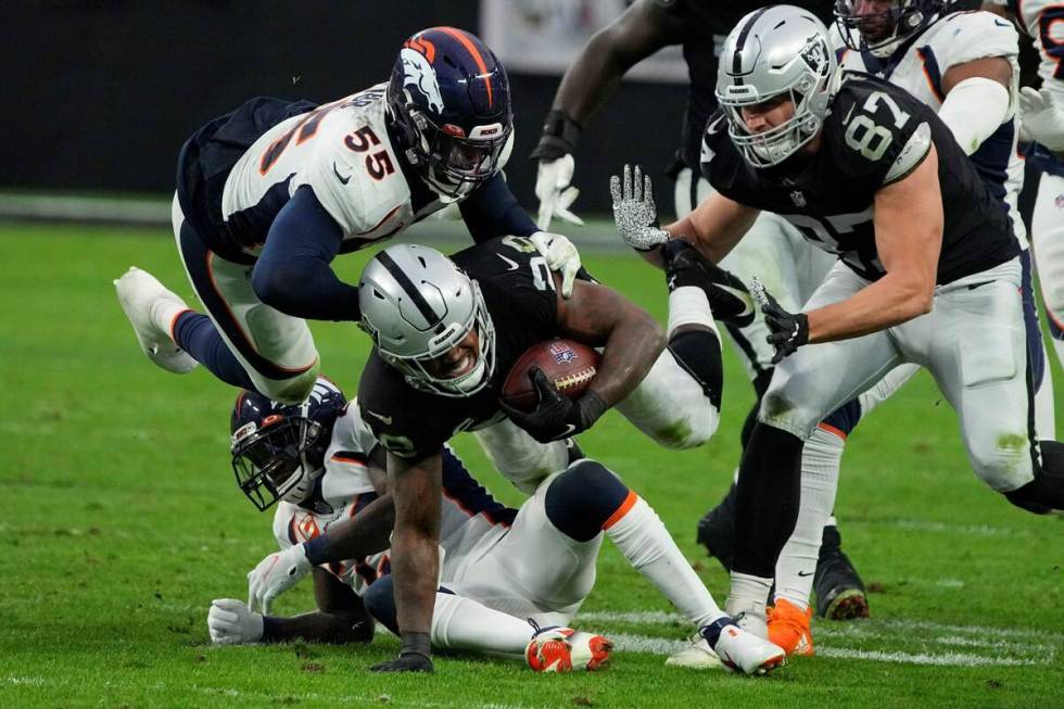 Las Vegas Raiders running back Josh Jacobs (28) dives for a gain against Denver Broncos outside ...