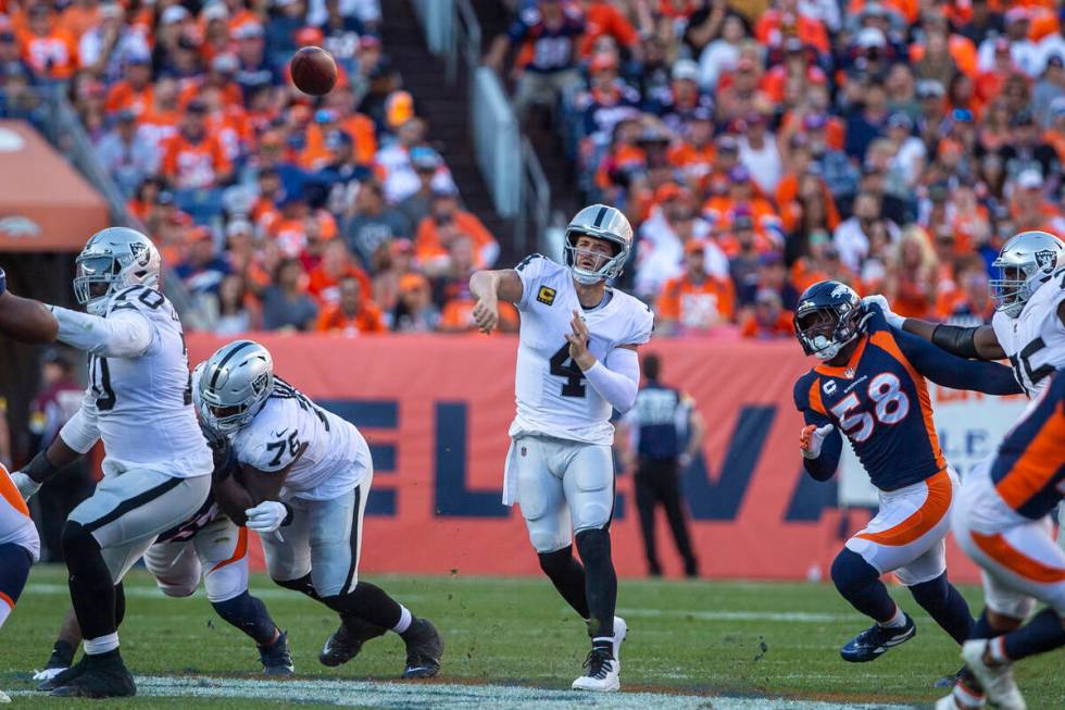 Raiders quarterback Derek Carr (4) throws as Denver Broncos outside linebacker Von Miller (58) ...