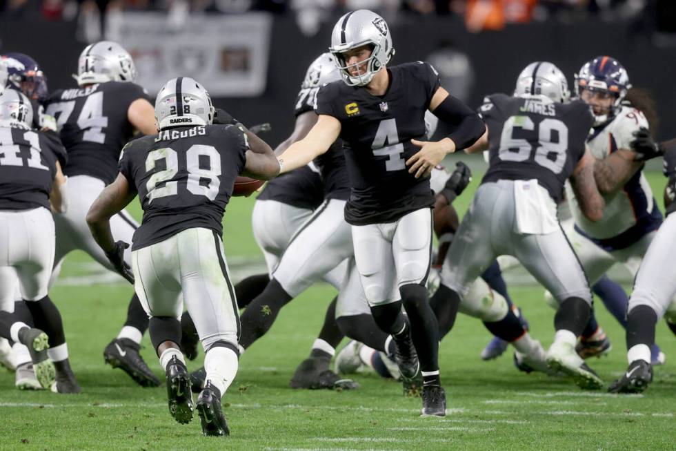 Raiders quarterback Derek Carr (4) hands off the ball to Raiders running back Josh Jacobs (28) ...