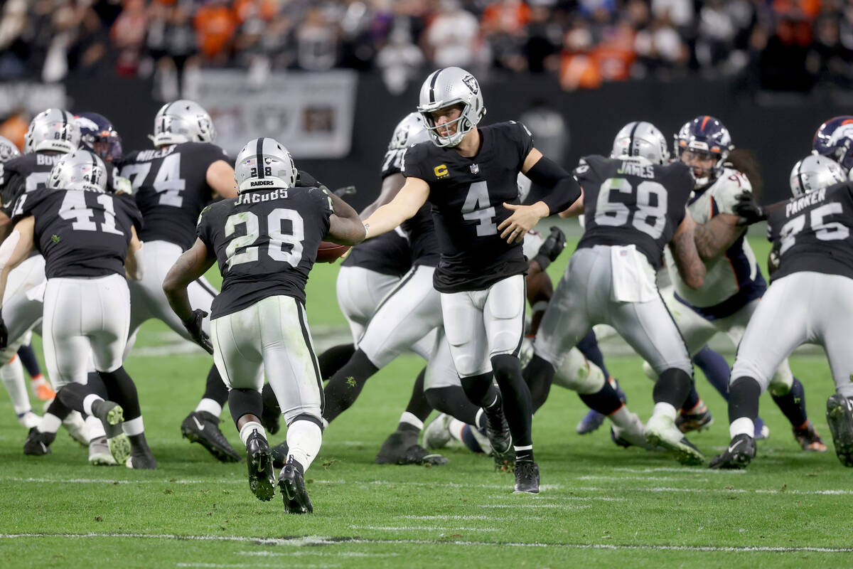 Raiders quarterback Derek Carr (4) hands off the ball to Raiders running back Josh Jacobs (28) ...