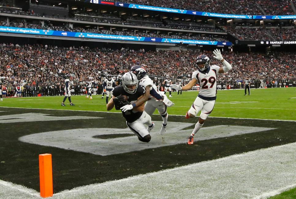 Raiders wide receiver Hunter Renfrow (13) scores a touchdown under pressure from Denver Broncos ...