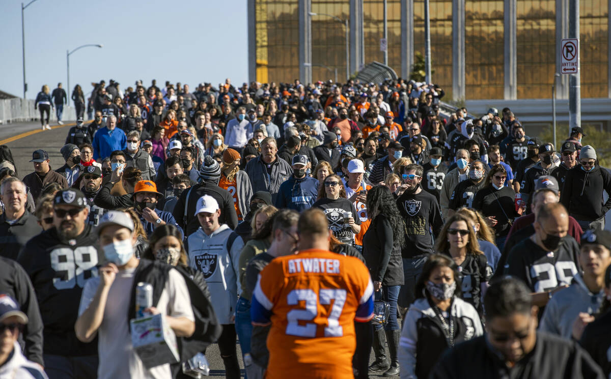 Raiders and Denver Broncos fans walk over thew Hacienda Avenue bridge on the north side before ...