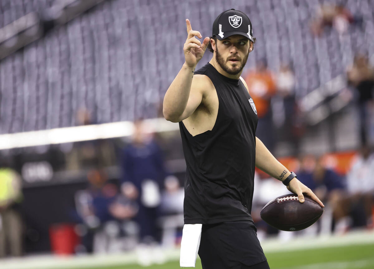 Raiders quarterback Derek Carr motions to fans before an NFL football game against the Denver B ...