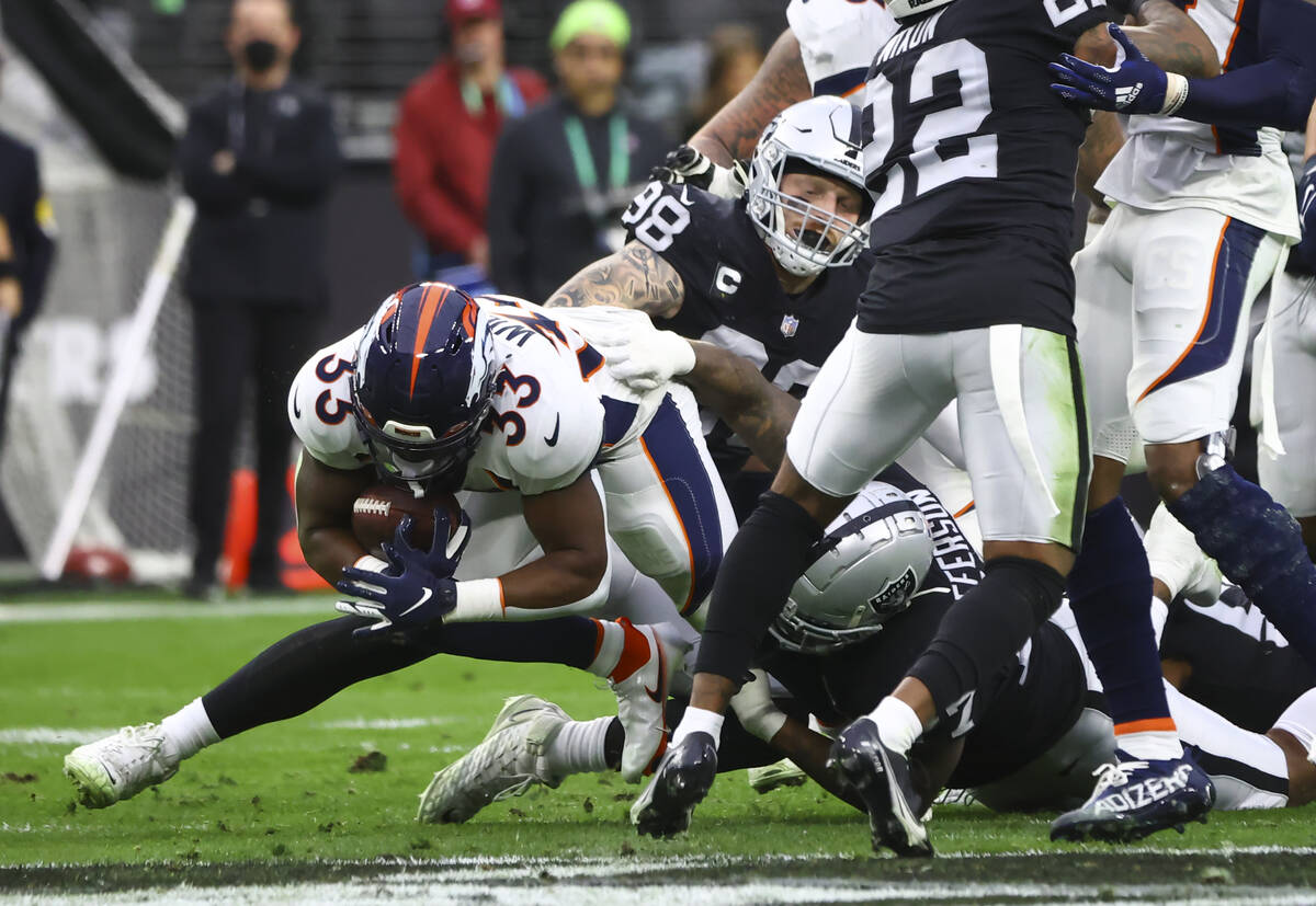 Raiders defensive tackle Quinton Jefferson (77) tackles Denver Broncos running back Javonte Wil ...
