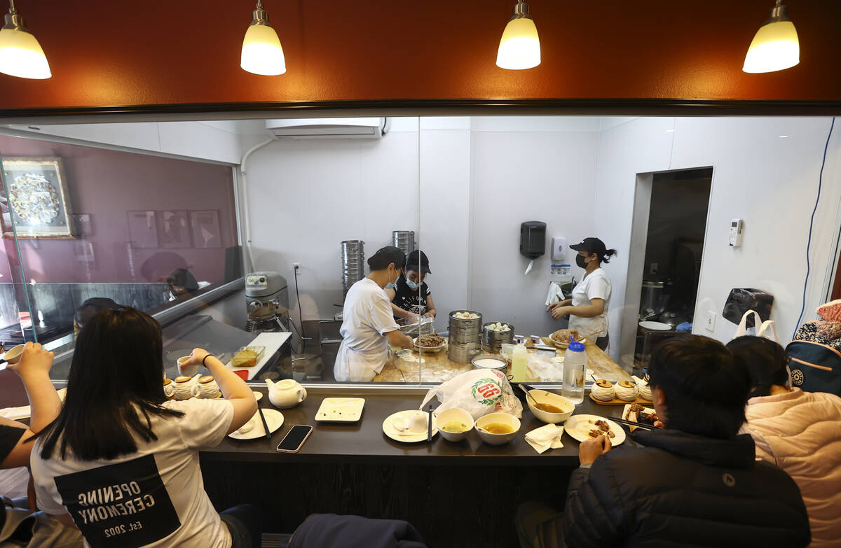 People dine as employees cook food at ShangHai Taste in Chinatown’s Shanghai Plaza in La ...