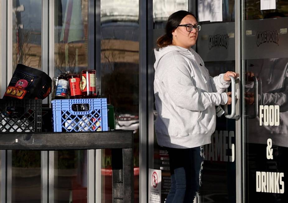 A worker removes liquor and locks the door at the GameWorks arcade and entertainment complex at ...