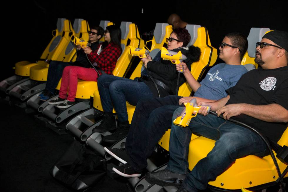 Bryan Fernandez, from right, his son Bryson and wife Leila experience the XD Dark Ride at GameW ...
