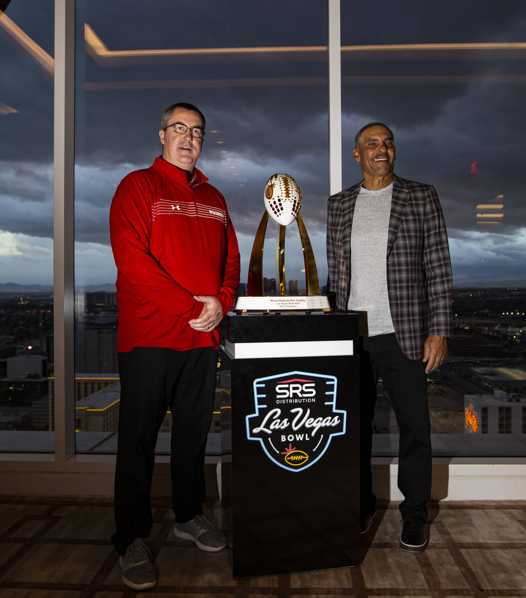 Wisconsin coach Paul Chryst, left, and Arizona State coach Herm Edwards pose with the trophy du ...