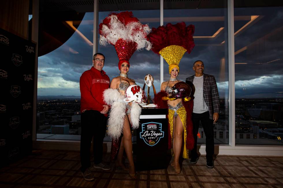 Wisconsin coach Paul Chryst, left, and Arizona State coach Herm Edwards, right, pose with showg ...