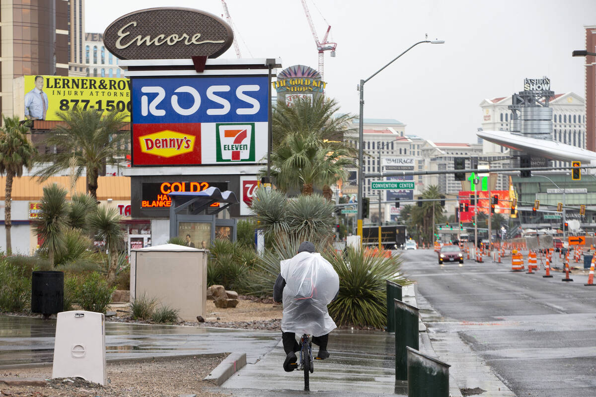 A bicyclist wears a garbage bag to stay dry from the rain while traveling south on the Las Vega ...