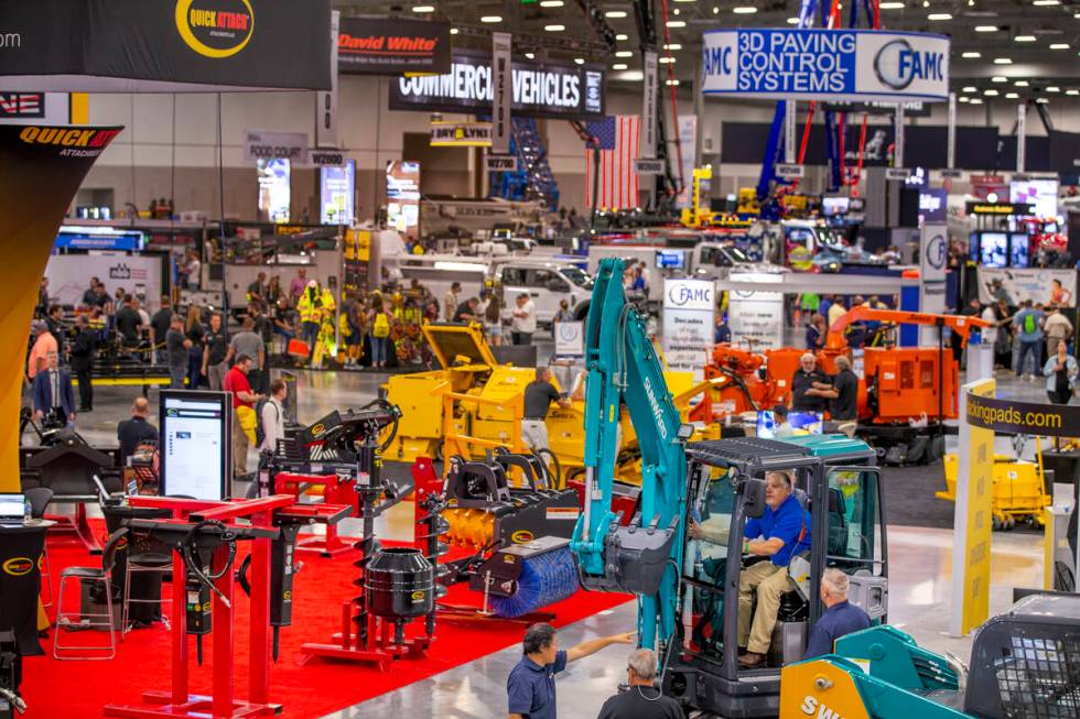 World of Concrete 2021 attendees check out a Sunward excavator at a display about the trade-sho ...