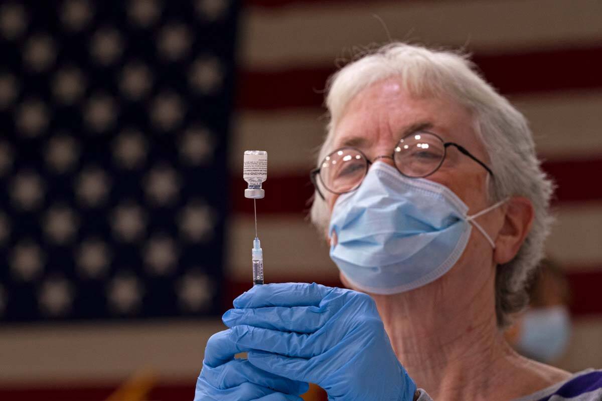 Pam Hetherly fills a syringe with COVID-19 vaccine at a clinic at the Augusta Armory, Dec. 21, ...