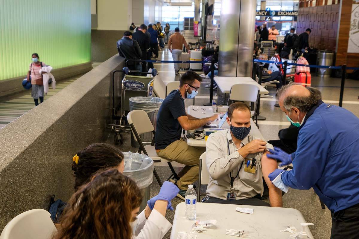 A traveler is vaccinated at the Los Angeles International Airport in Los Angeles, Wednesday Dec ...