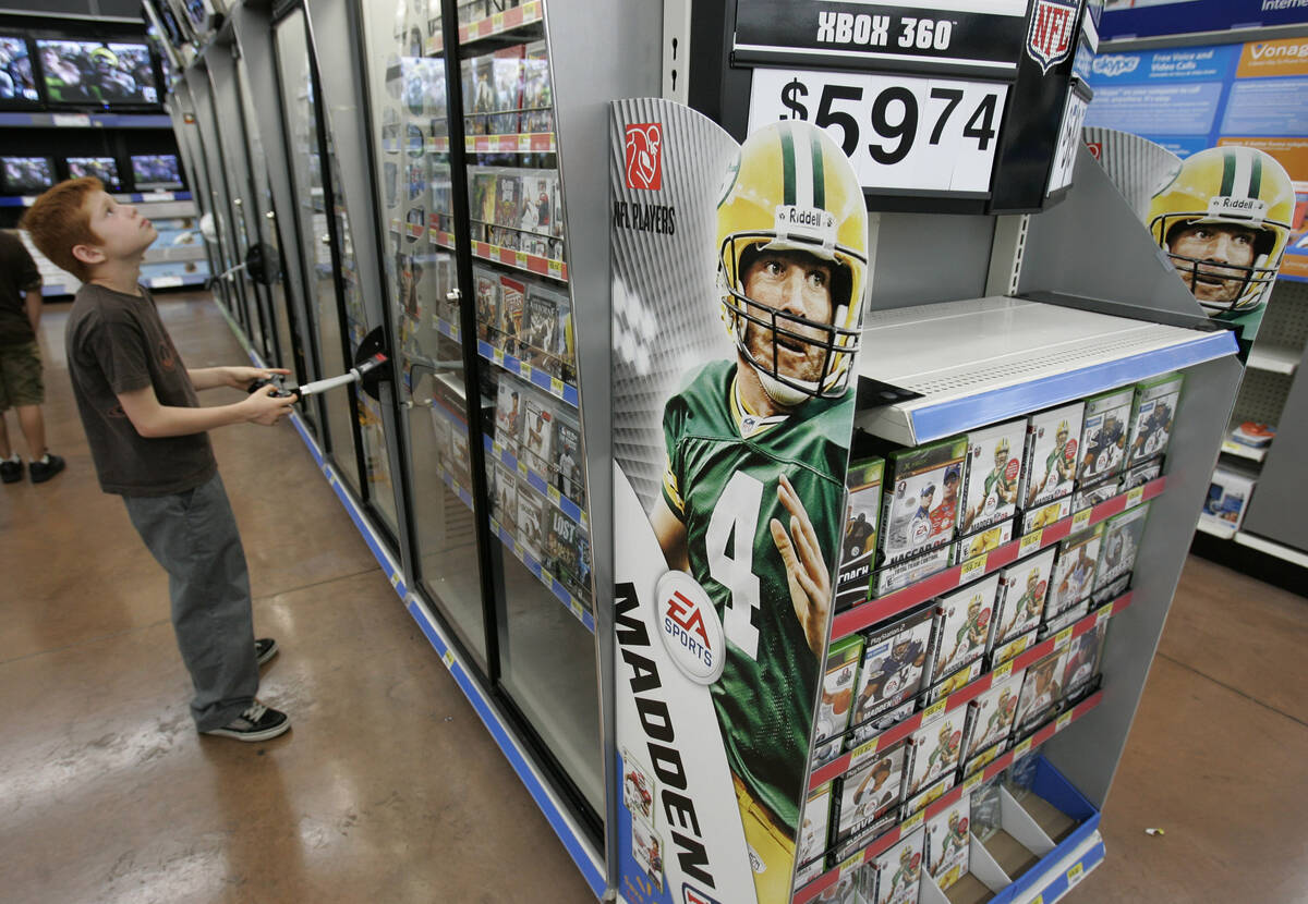 Walmart customer plays on a video game as the new Electronic Arts game Madden 2009 on display a ...