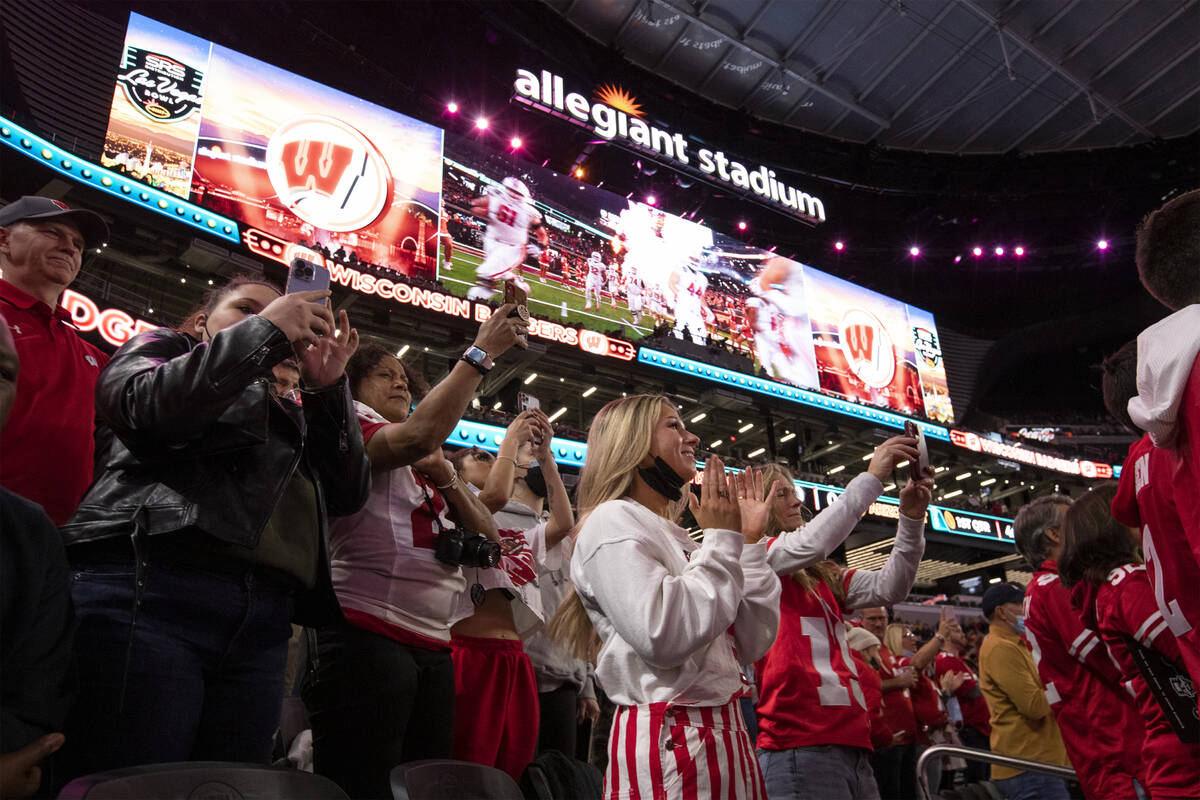 Wisconsin Badgers fans cheer as their team takes the field at Allegiant Stadium before the Las ...