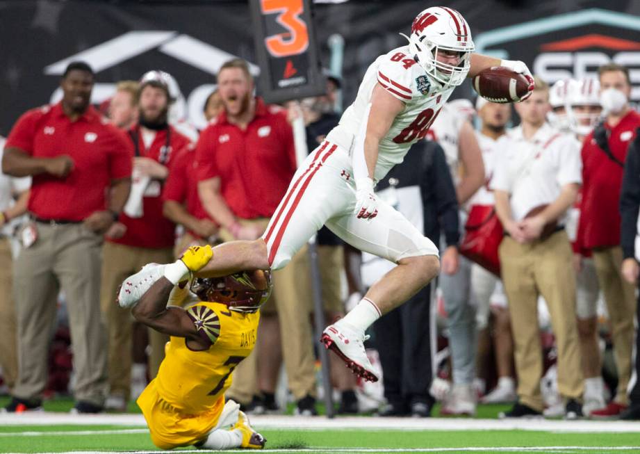 Wisconsin Badgers tight end Jake Ferguson (84) jumps to evade a tackle by Arizona State Sun Dev ...
