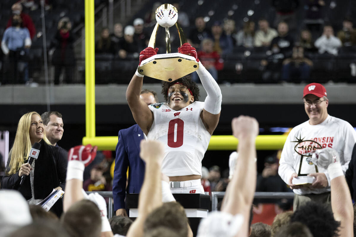 Wisconsin Badgers running back Braelon Allen (0) holds up the game-winning trophy while his tea ...