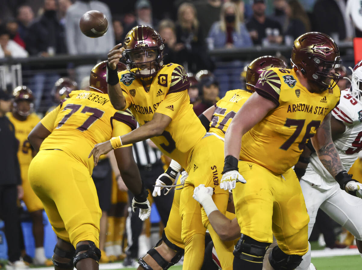 Arizona State Sun Devils quarterback Jayden Daniels (5) throws a pass while being tackled by th ...