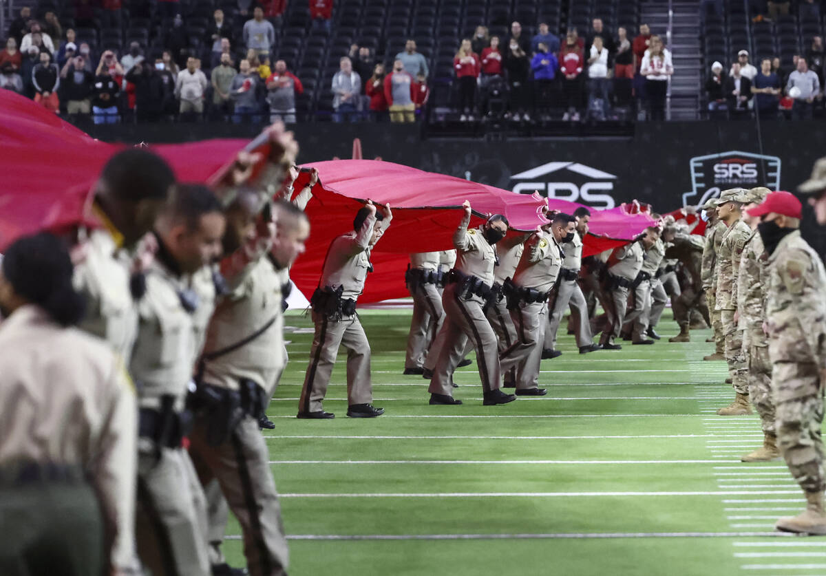 Las Vegas police officers display the U.S. flag across the field before the Las Vegas Bowl NCAA ...