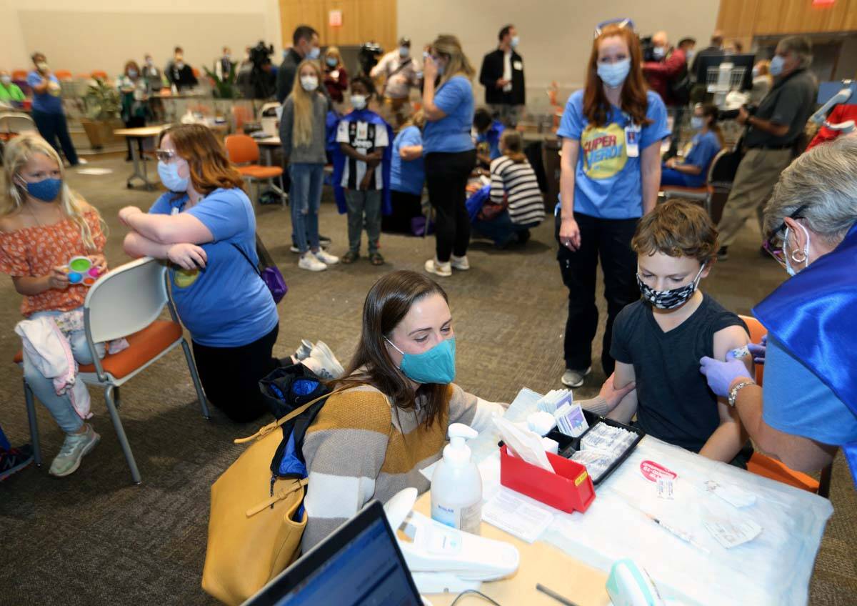 Retired registered nurse Jill Rill, right, puts a bandage on Jackson Stukus, 11, after he recei ...