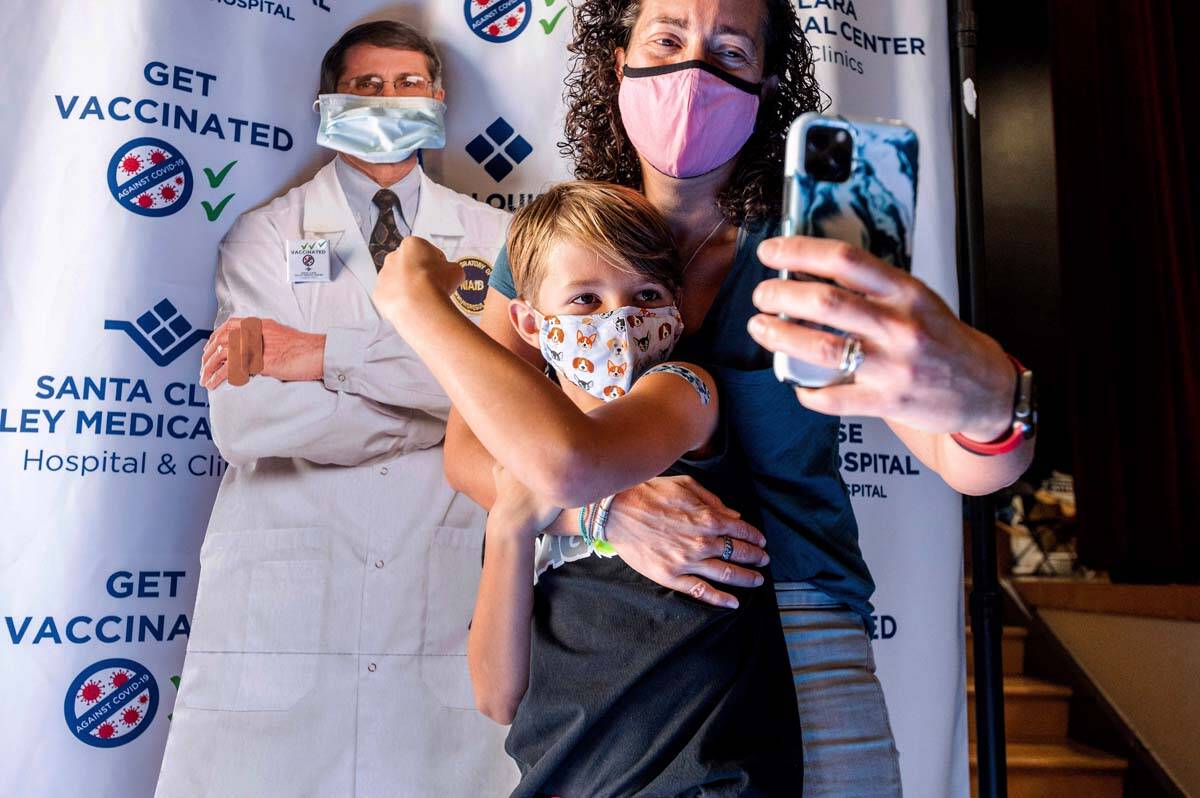 Finn Washburn, 9, shows his vaccination site as his mother, Kate Elsley, takes a photo shortly ...