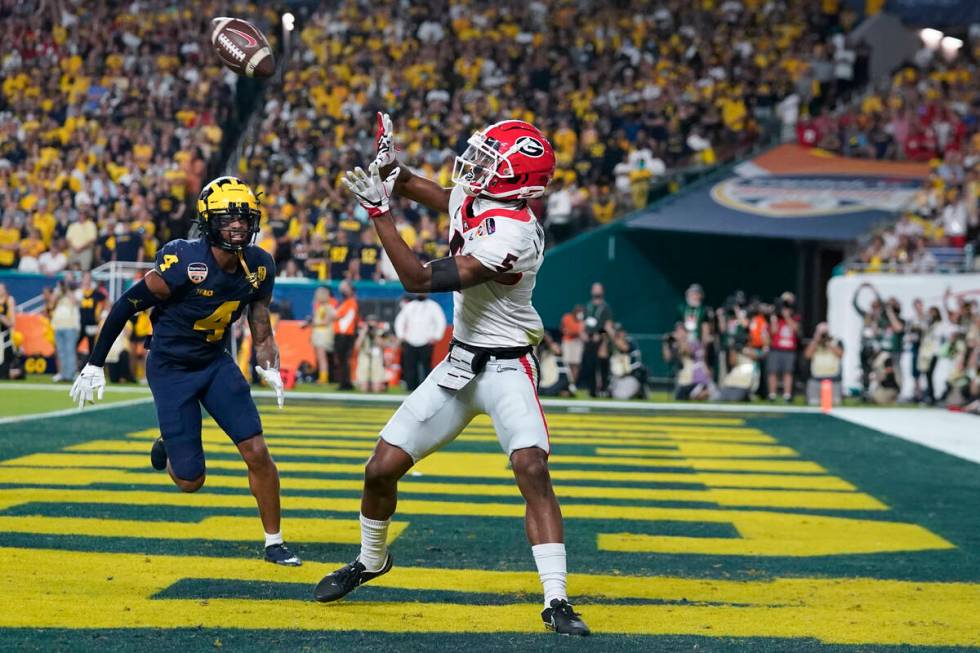 Georgia wide receiver Adonai Mitchell catches a touchdown pass as Michigan defensive back Vince ...