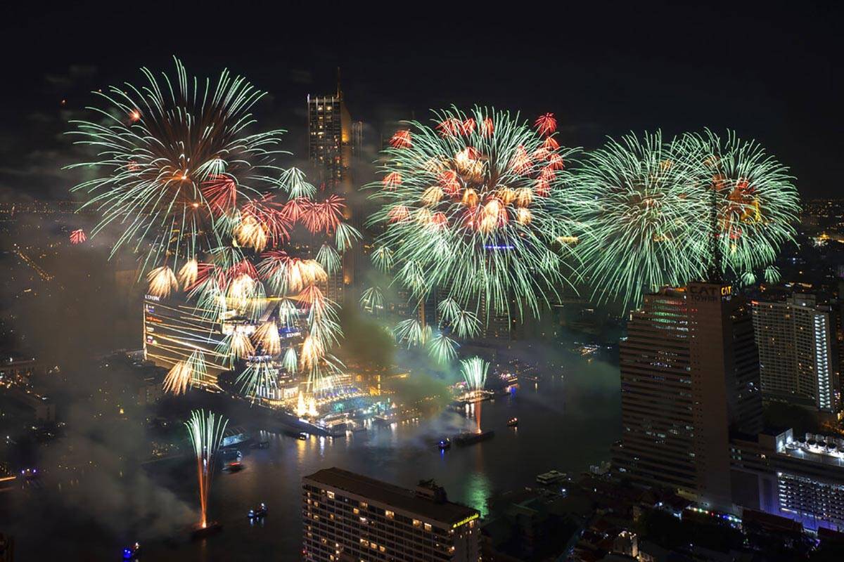 Fireworks explode over the Chao Phraya River during New Year celebrations in Bangkok, Thailand, ...