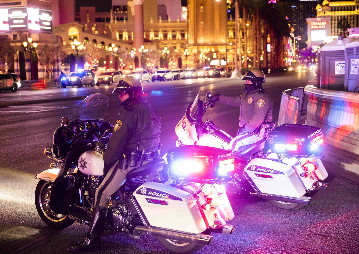 Law enforcement watch New Year’s Eve crowds walk the Strip on Friday, Dec. 31, 2021, in ...