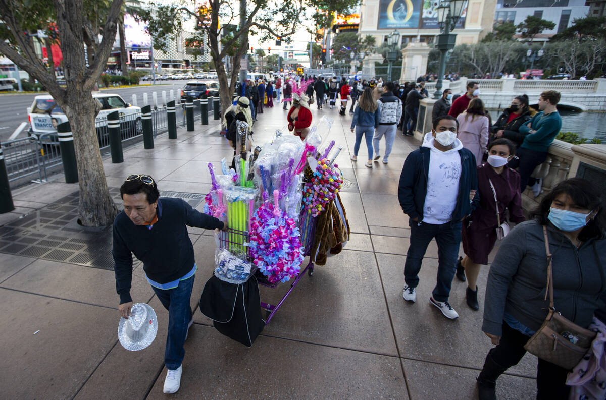 People walk the Strip near the Bellagio hotel-casino during New Year’s Eve in Las Vegas, ...