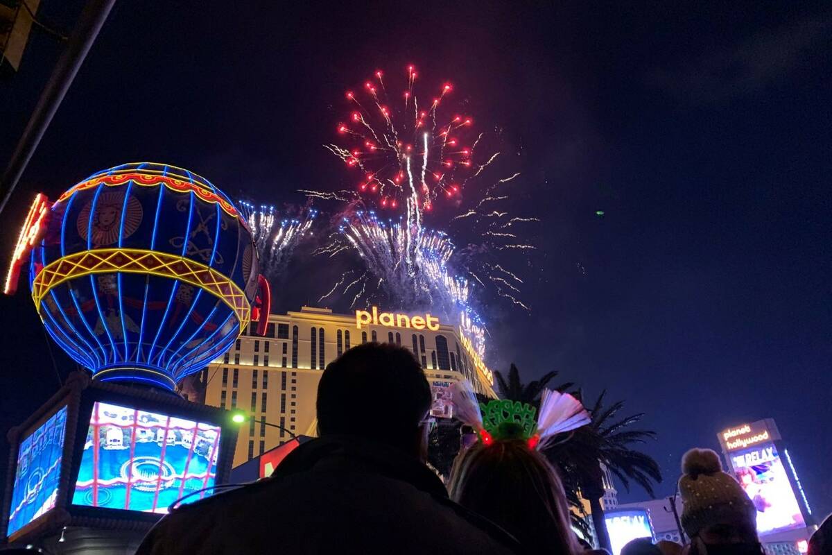 People watch fireworks on the Las Vegas Strip on Friday, Dec. 31, 2021. (Chitose Suzuki/Las Veg ...